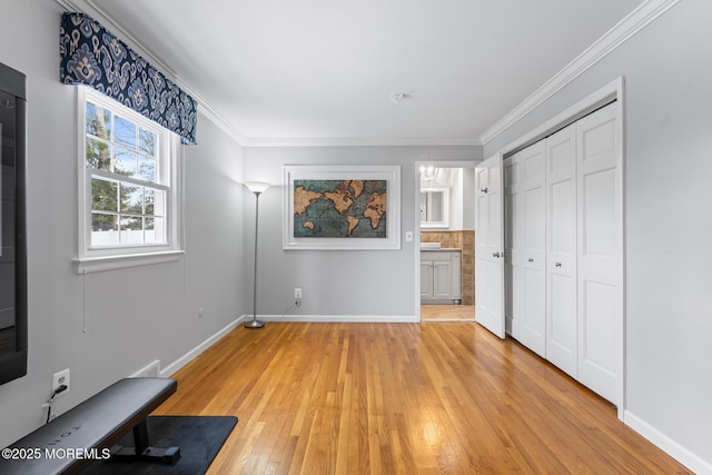 unfurnished bedroom featuring ornamental molding, a closet, and light wood-type flooring