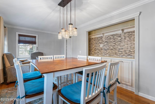 dining room featuring an inviting chandelier, hardwood / wood-style flooring, and ornamental molding