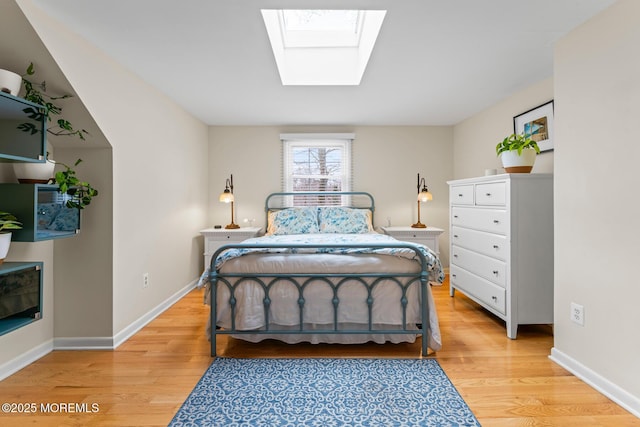 bedroom featuring light hardwood / wood-style flooring and a skylight