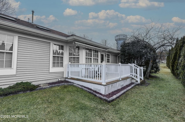 rear view of property featuring a wooden deck and a yard