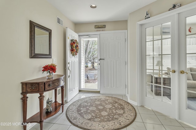 foyer with light tile patterned floors and french doors