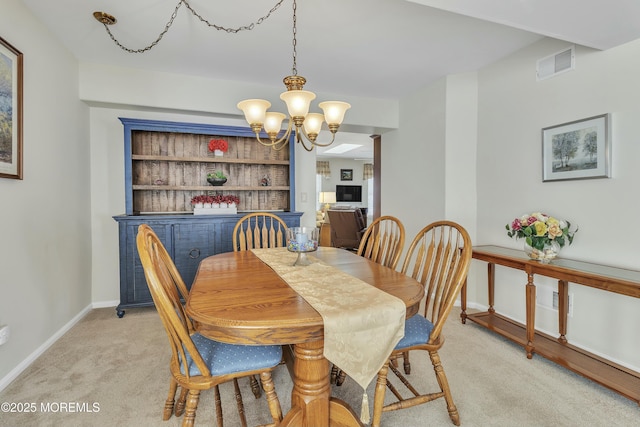 dining area featuring light carpet, a notable chandelier, and ornate columns