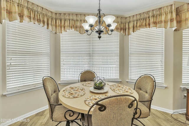 dining space with a notable chandelier and light wood-type flooring