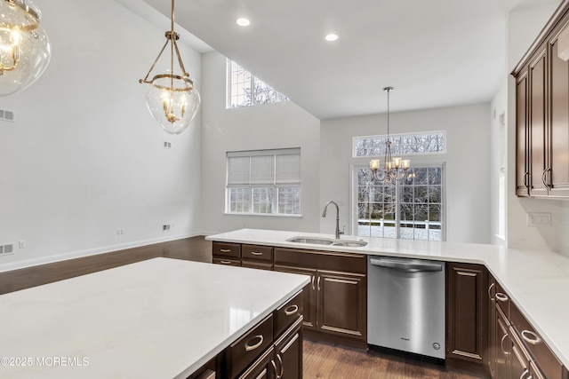 kitchen featuring pendant lighting, sink, stainless steel dishwasher, and a notable chandelier