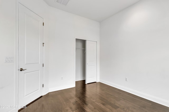 unfurnished bedroom featuring dark hardwood / wood-style flooring and a closet