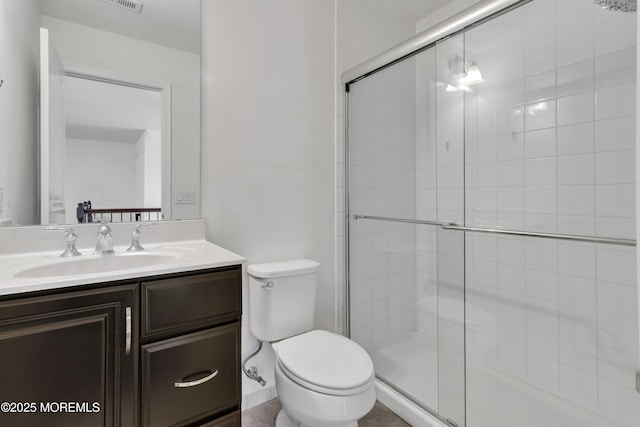 bathroom with a shower with door, vanity, and toilet