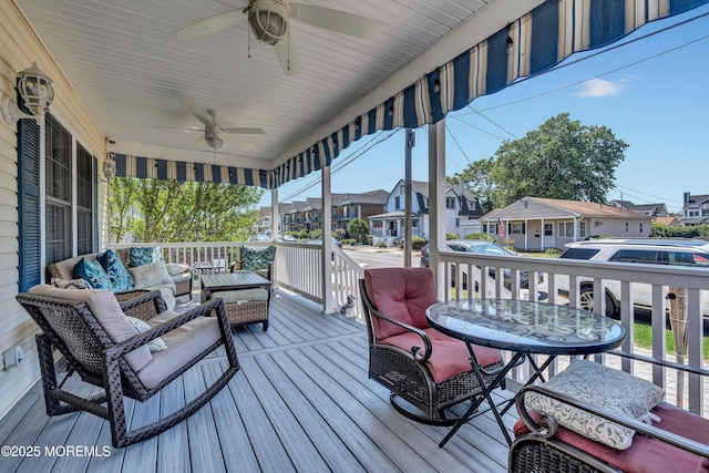 wooden deck featuring ceiling fan, an outdoor living space, and covered porch