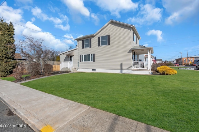 back of house featuring a lawn and covered porch