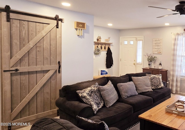 living room featuring a barn door and ceiling fan