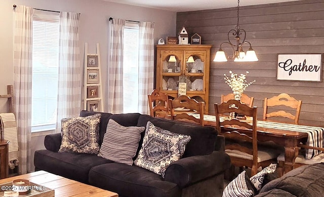 living room featuring an inviting chandelier and wooden walls