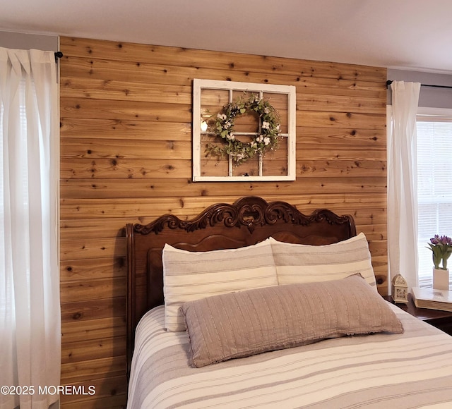 bedroom with multiple windows and wooden walls