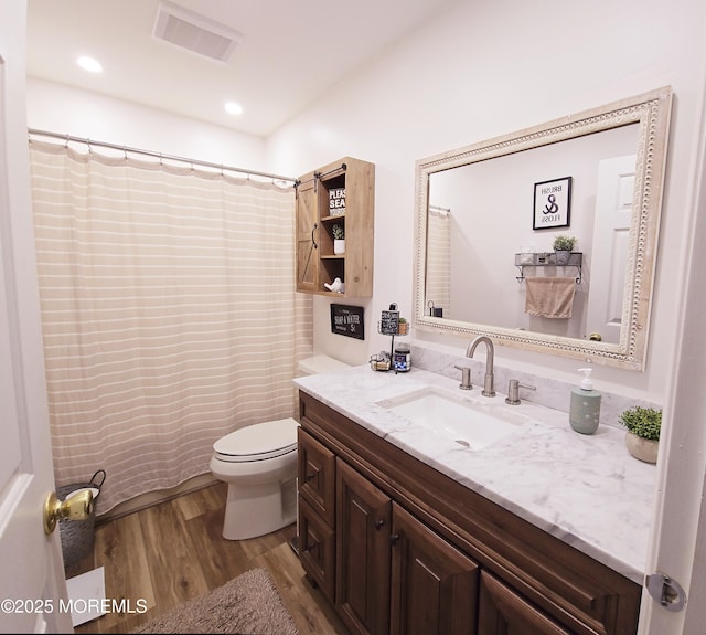 bathroom featuring vanity, hardwood / wood-style floors, a shower with curtain, and toilet