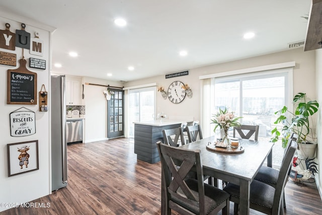 dining space featuring dark wood-type flooring and plenty of natural light