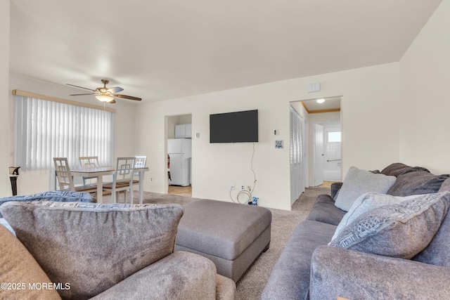 living room with a wealth of natural light, light colored carpet, and ceiling fan