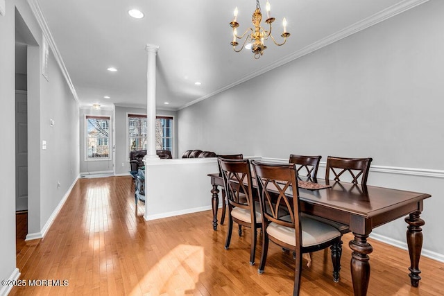 dining space with an inviting chandelier, ornamental molding, light hardwood / wood-style floors, and ornate columns