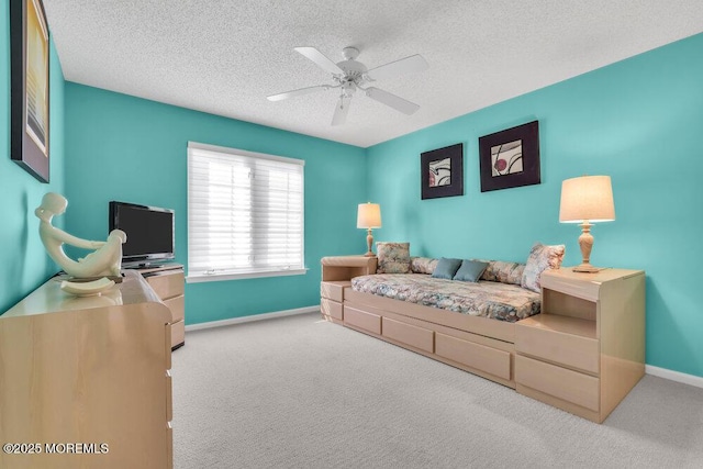 bedroom with ceiling fan, light carpet, and a textured ceiling