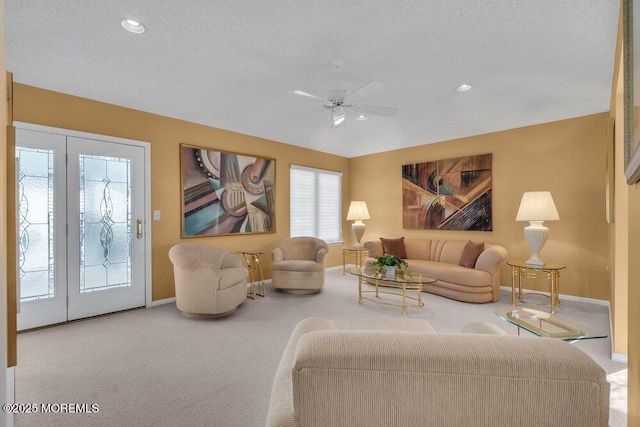 living room featuring vaulted ceiling, carpet floors, ceiling fan, and a textured ceiling