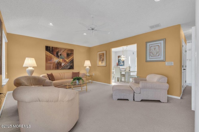 carpeted living room with ceiling fan and a textured ceiling