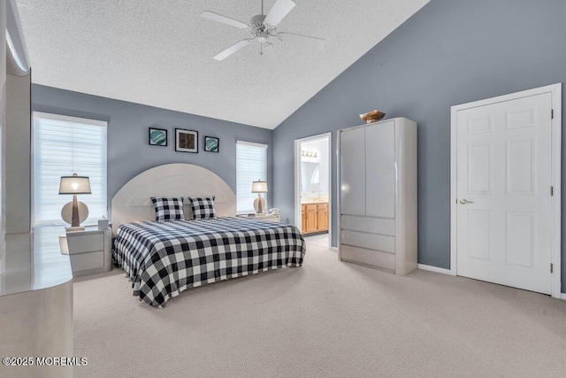 bedroom featuring ensuite bathroom, vaulted ceiling, light carpet, a textured ceiling, and ceiling fan