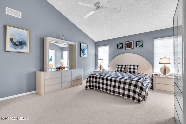 carpeted bedroom with ceiling fan, vaulted ceiling, and a textured ceiling