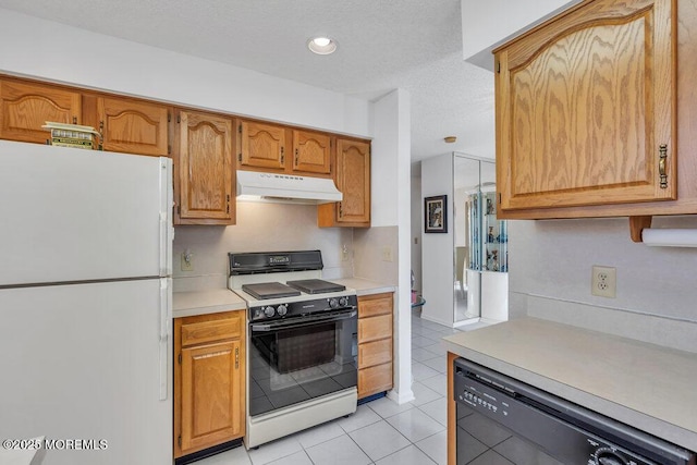 kitchen with dishwasher, white fridge, range, light tile patterned floors, and a textured ceiling