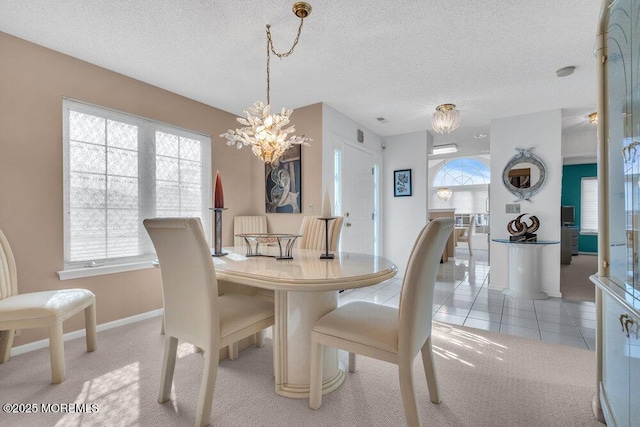 dining room with light colored carpet, a chandelier, and a textured ceiling