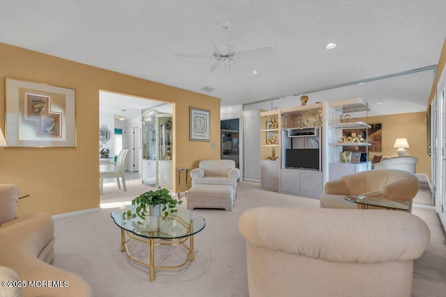 carpeted living room with ceiling fan and a textured ceiling