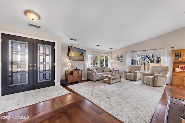 living room featuring wood-type flooring, vaulted ceiling, and french doors