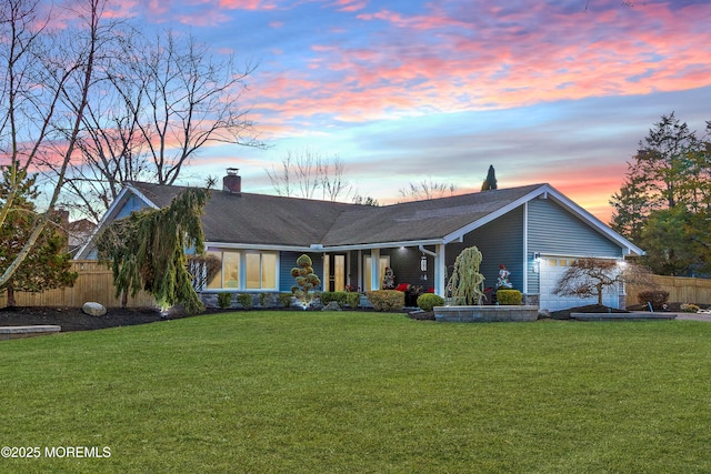 ranch-style house featuring a yard and a garage