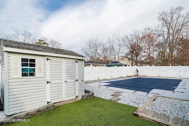 view of swimming pool featuring a storage unit, a yard, and a patio area