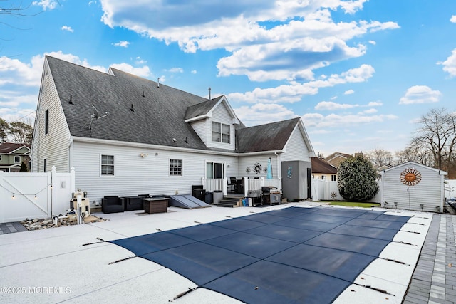 rear view of property featuring a covered pool