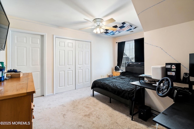 bedroom featuring light carpet, ceiling fan, and a closet