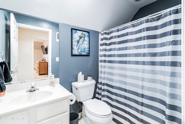 bathroom with vanity, vaulted ceiling, and toilet