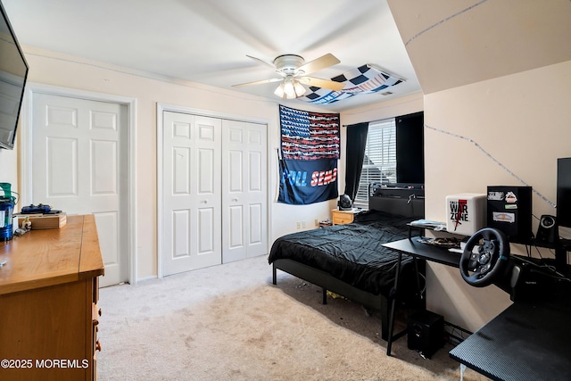 carpeted bedroom with ceiling fan and a closet