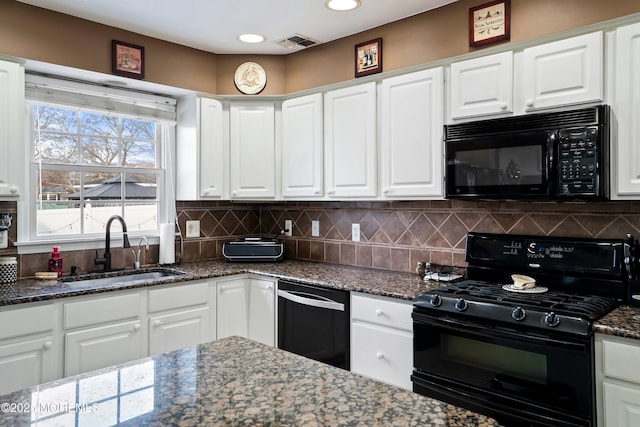 kitchen with sink, white cabinets, decorative backsplash, dark stone counters, and black appliances