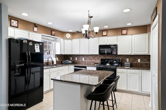 kitchen featuring hanging light fixtures, a center island, white cabinets, and black appliances