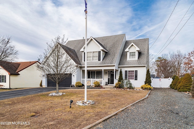 view of front of property featuring a garage, a front yard, and a porch