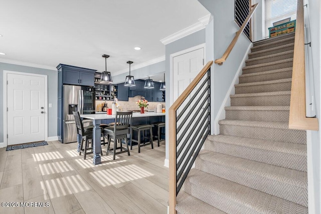 staircase featuring hardwood / wood-style floors and crown molding