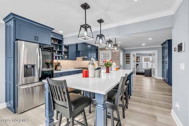 dining space with ornamental molding and light hardwood / wood-style floors