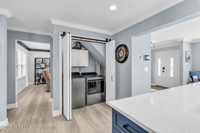 kitchen featuring light hardwood / wood-style floors, separate washer and dryer, and ornamental molding