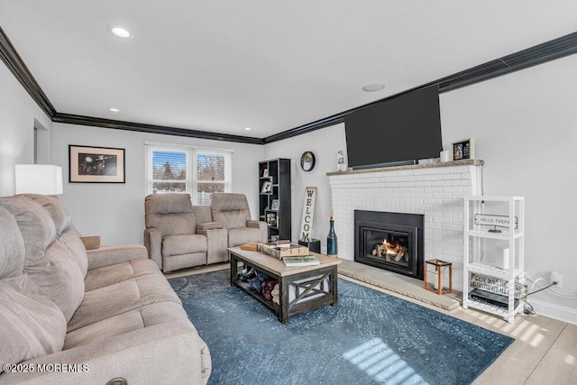 living room featuring a fireplace, crown molding, and wood-type flooring