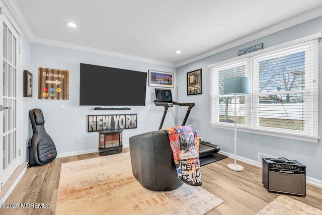 exercise area with crown molding and hardwood / wood-style floors