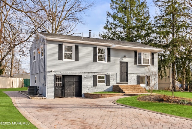 raised ranch with a garage and central AC unit