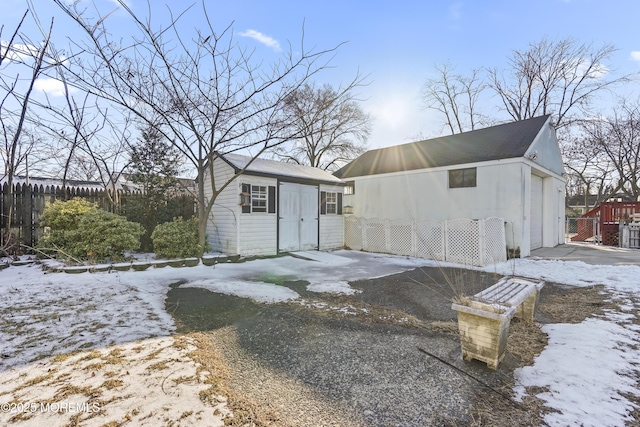 snow covered house featuring an outbuilding