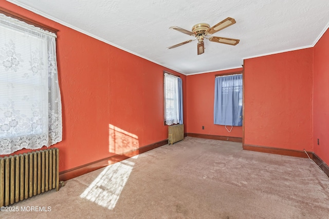 spare room with radiator, ornamental molding, light colored carpet, and a textured ceiling