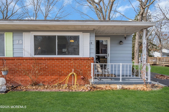 entrance to property featuring a lawn and a porch