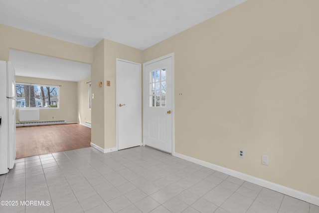 unfurnished room featuring light tile patterned flooring and a baseboard heating unit