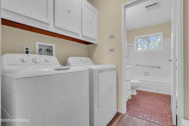 washroom featuring washer and clothes dryer and cabinets