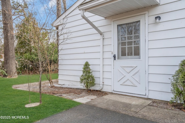 doorway to property with a yard