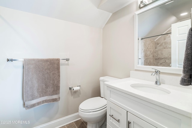 bathroom with vanity, toilet, vaulted ceiling, and wood-type flooring